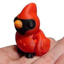 Load image into Gallery viewer, A compact, high-density articulated cardinal figure with a bright red body, black facial markings, and an orange beak. The figure features subtle wing articulation and sits in the palm of a hand, showcasing its small size and smooth finish by Convixxion.