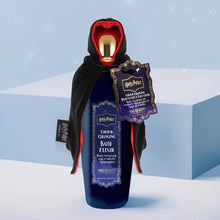 Load image into Gallery viewer, Harry Potter color changing bath elixir by Mad Beauty, in a dark blue bottle with gold cap dressed in a black hooded cloak with red lining and hang tag, standing on a light blue block with a soft blue background.