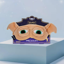 Load image into Gallery viewer, Harry Potter Dobby sleep mask by Mad Beauty, shaped like Dobby’s face with green eyes and floppy ears, displayed on its purple backing card and propped on a light blue block with a soft blue background.