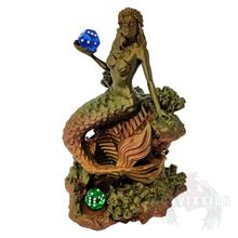 Load image into Gallery viewer, Front view of the Mermaid Dice Tower in vintage metal color. The mermaid holds a blue die in her hand and a green die resting at the bottom of the tray. The design features intricate details and a sea-inspired theme, showcasing the tower's unique aesthetic.