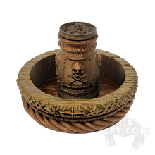 Load image into Gallery viewer, Front view of a pirate-themed dice cup and tray set, featuring a dark metallic gradient with rich gold and copper tones. The dice cup sits inside the matching tray, both designed with intricate details perfect for tabletop gaming.