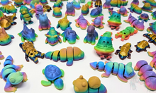 Load image into Gallery viewer, A collection of colorful 3D printed fidget animals in Silk Rainbow, Gloss Rainbow, and Matte Rainbow finishes, arranged on a white background. Includes various articulated designs such as unicorns, dragons, and caterpillars.
