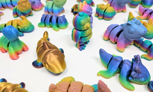 Load image into Gallery viewer, A variety of 3D printed fidget animals in various rainbow finishes, featuring detailed and articulated designs such as dragons, axolotls, pigs, bees, brontos, and turkeys, placed on a plain background.
