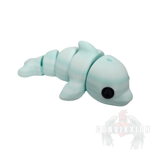 Light-colored 3D-printed mini dolphin fidget with black eyes and articulation, designed for tactile movement and stress relief.