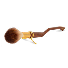 Load image into Gallery viewer, Harry Potter broom-shaped makeup brush by Mad Beauty on a white background, featuring a curved wood-effect handle, gold ferrule, and soft fluffy bristles, collectible cosmetic brush for Harry Potter makeup and gift sets.
