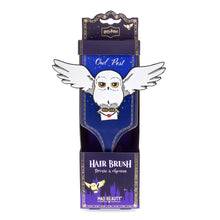 Load image into Gallery viewer, Harry Potter Hedwig “Owl Post” hair brush by Mad Beauty, shown upright in purple packaging with Hedwig flying and holding a Hogwarts letter on the brush handle, on a white background.

