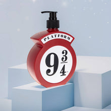 Load image into Gallery viewer, Harry Potter Platform 9 3/4 hand and body wash by Mad Beauty, in a red pump bottle shaped like the Platform 9 3/4 sign, displayed on stepped light blue blocks with a soft blue background.
