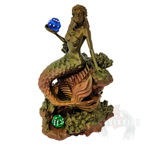 Front view of the Mermaid Dice Tower in vintage metal color. The mermaid holds a blue die in her hand and a green die resting at the bottom of the tray. The design features intricate details and a sea-inspired theme, showcasing the tower's unique aesthetic.