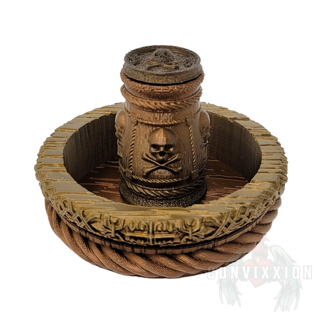 Front view of a pirate-themed dice cup and tray set, featuring a dark metallic gradient with rich gold and copper tones. The dice cup sits inside the matching tray, both designed with intricate details perfect for tabletop gaming.