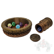 Load image into Gallery viewer, Pirate themed dice cup and tray set with a dark metallic gradient, lying on its side with a die spilling out. Several dice rest inside the matching tray, showcasing the set’s intricate design and perfect fit for tabletop gaming.
